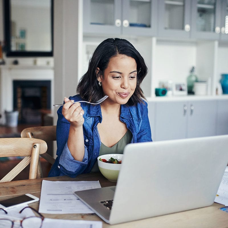 Woman enjoying breakfast while managing her Byline Bank accounts online.