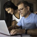 Adult daughter helping father work on finances