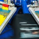 Automated silk screen printing rotary machine prints black t-shitrs