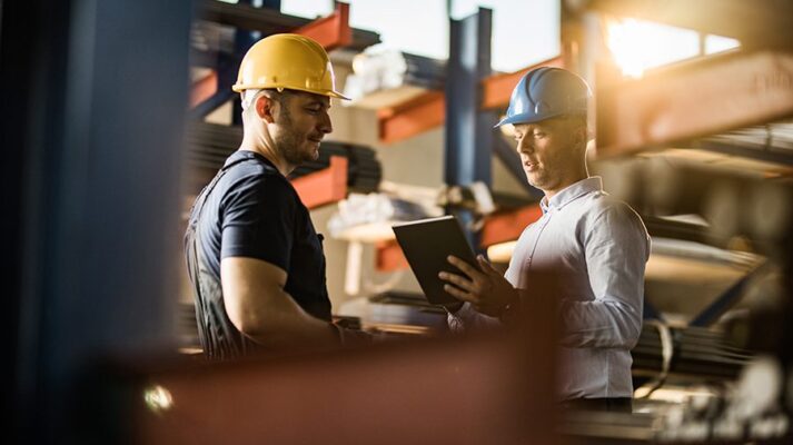 Small business owner and banker discuss funding in a warehouse
