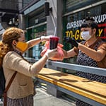 Woman handing woman a coffee