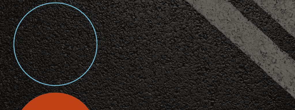 A textured asphalt surface with two diagonal white lines, a blue outlined circle at the top left, and a partial red circle at the bottom left.