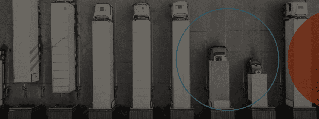 Aerial view of several semi-trucks and trailers parked in parallel rows at a lot, with two vehicles inside a highlighted blue circle.
