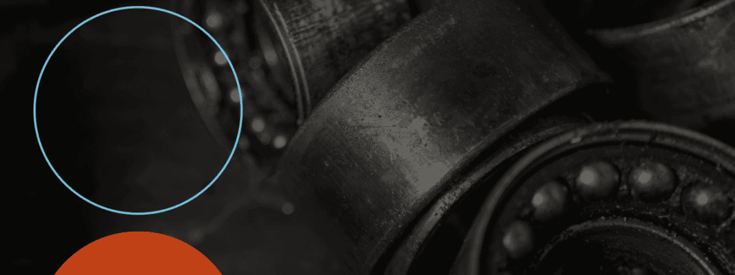 Close-up of metal ball bearings and circular parts, with a light blue outlined circle and an orange solid circle in the lower left corner.