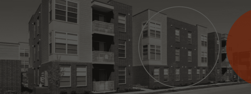 Modern brick apartment building with a blue circle highlighting a section of the facade.